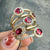 Ruby and diamond halo ring in 14K yellow gold, available at Santayana Jewelers Miami