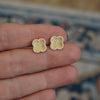 Clover shaped earrings with diamonds between fingers.