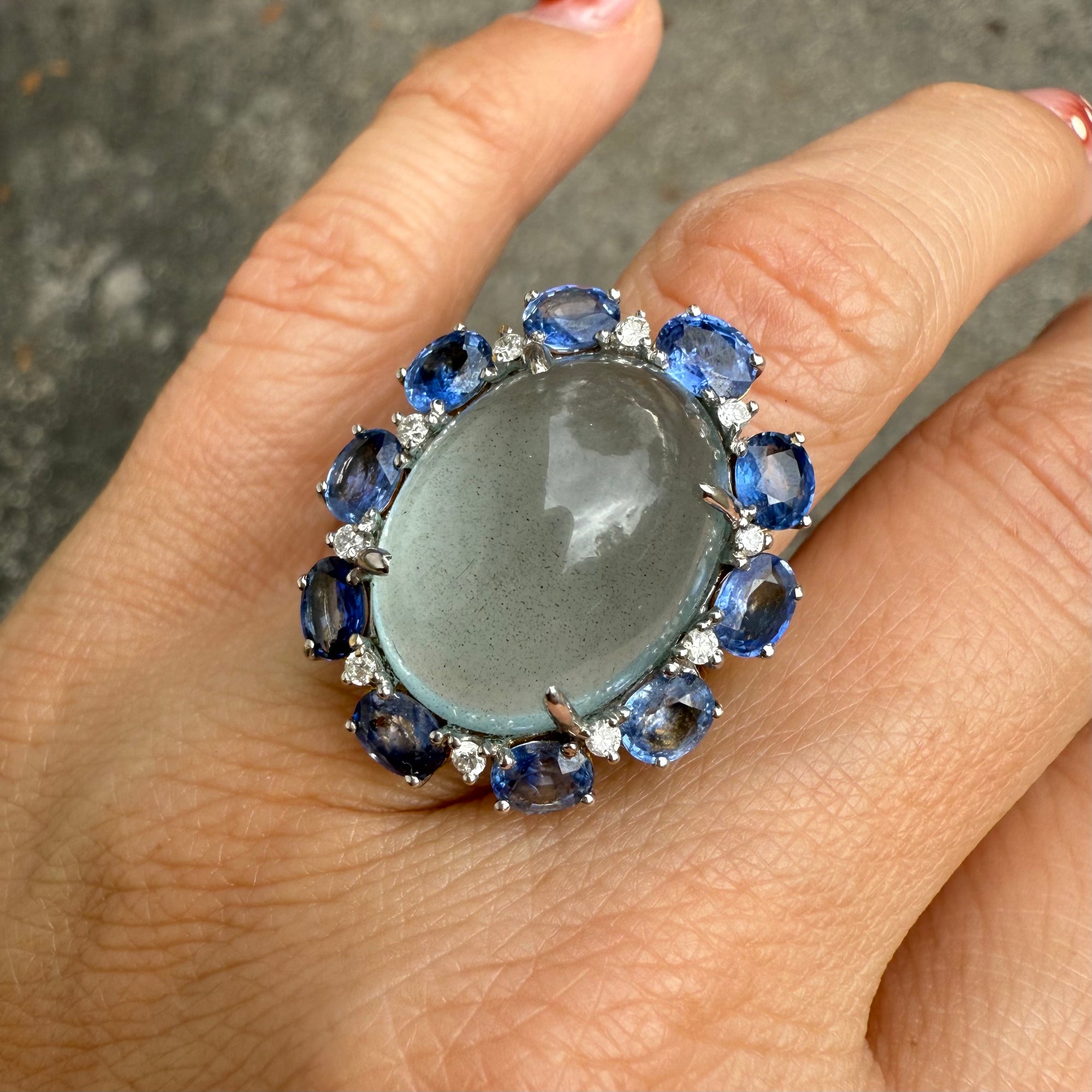 Side view of aquamarine, sapphire, and diamond cocktail ring in 14K gold