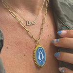 Model wearing medalla de la Virgen de la Caridad en ágata oro 14K Cuban jewelry Miami
